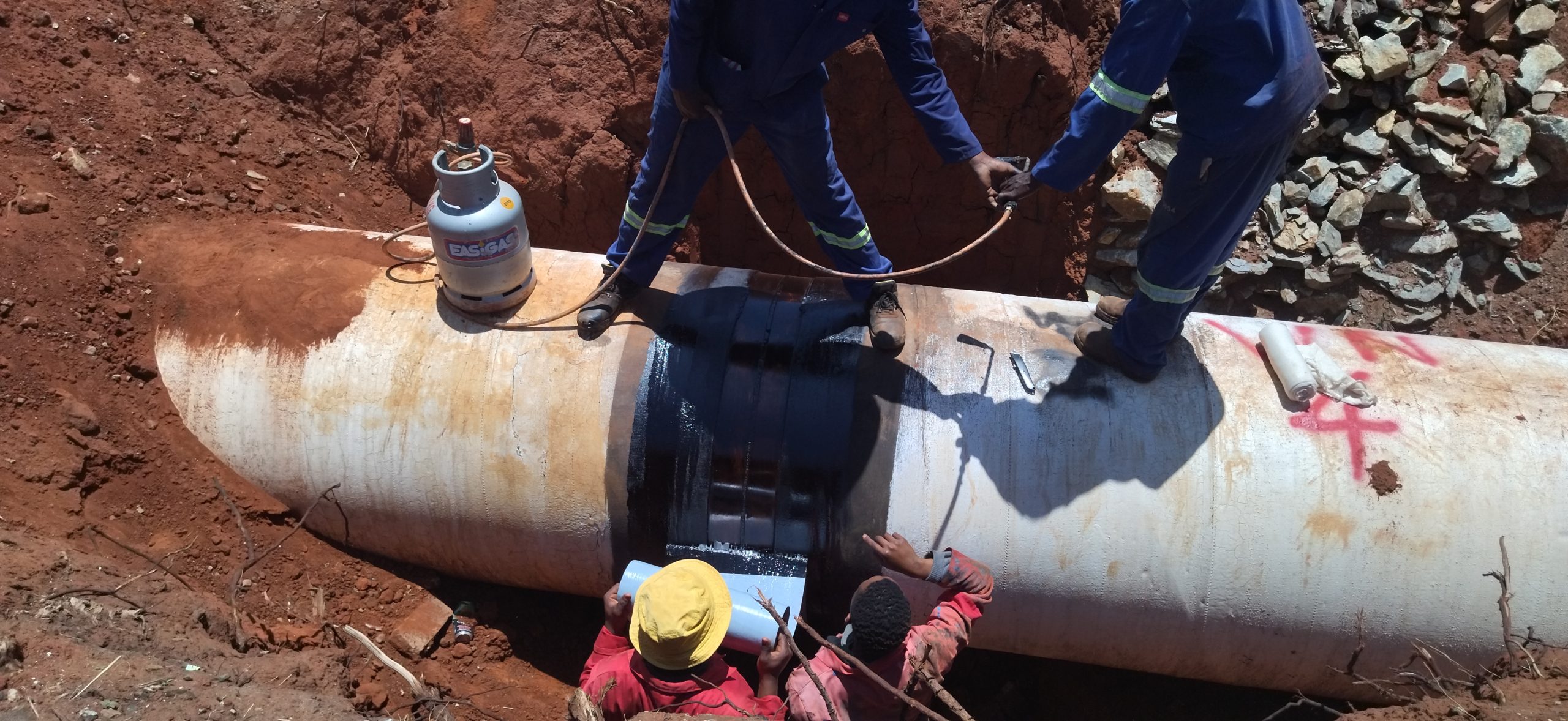 Coated steel pipe joint in a trench, corrosion protection applied on a Mbombi Holdings pipeline